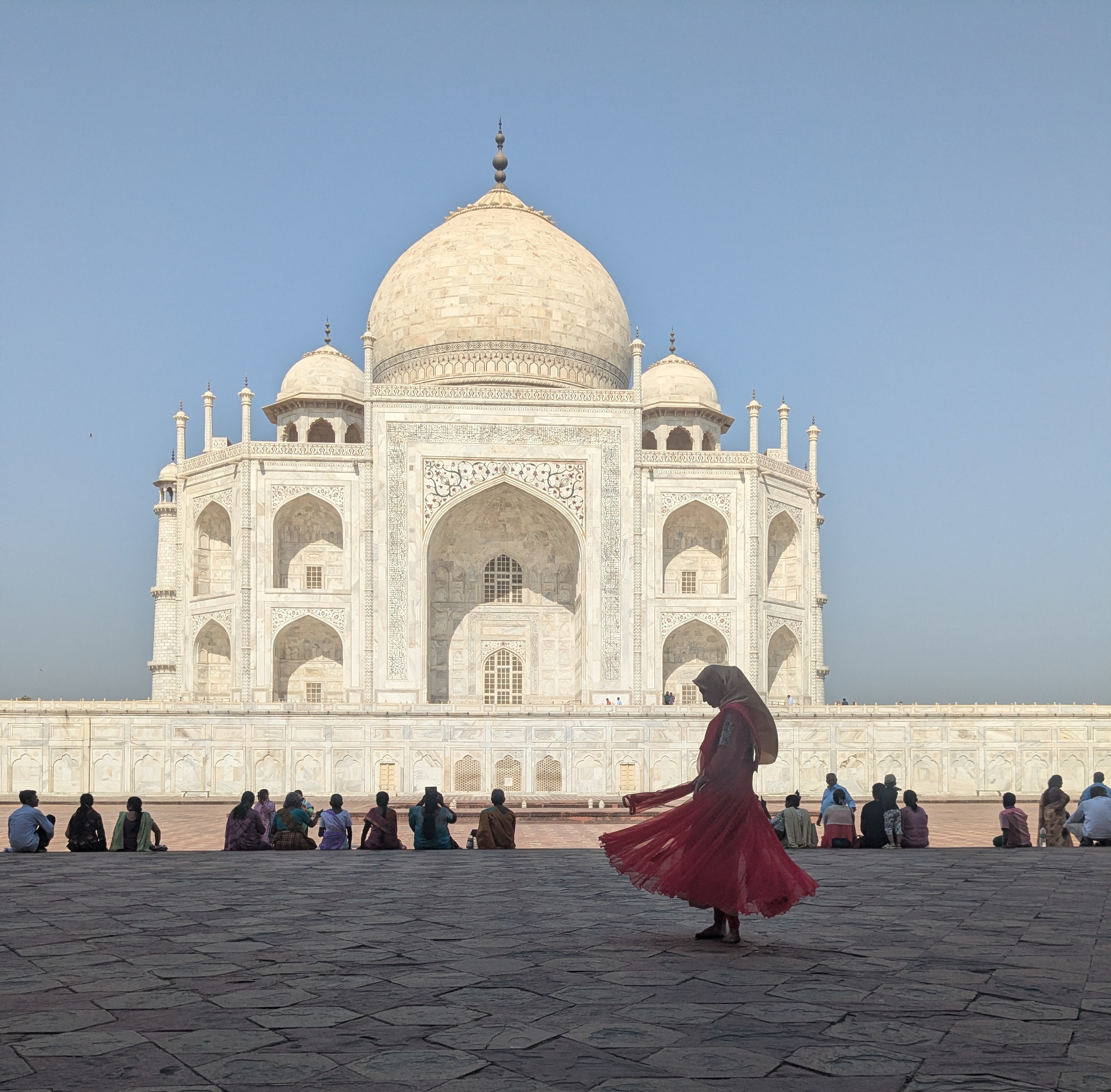 A traveller in red at the Taj Mahal at dawn